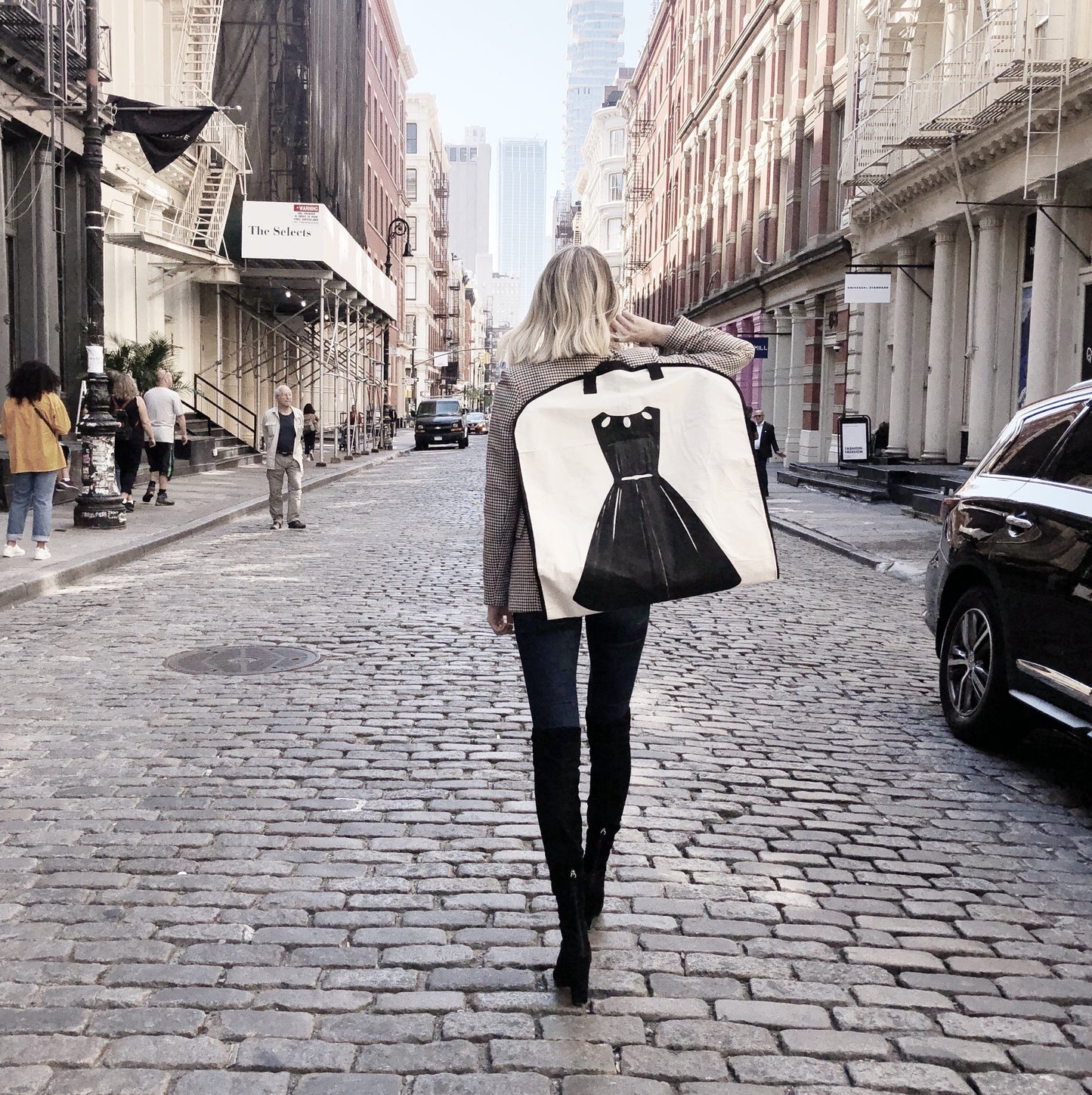 
                                      
                                        Sac à vêtements LBD tenu par une femme alors qu'elle marche dans la rue à New York.
                                      
                                    