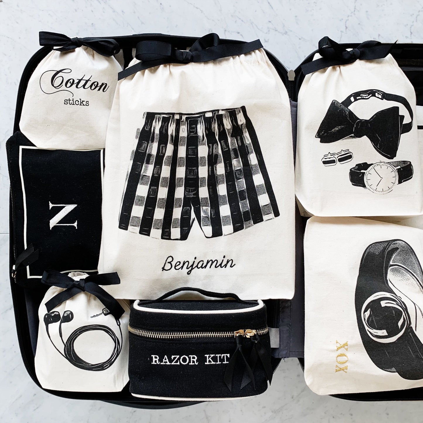
                                      
                                        Une valise contenant un étui pour écouteurs, un petit étui, un sac de ceinture, des accessoires pour hommes et un sac boxer.
                                      
                                    