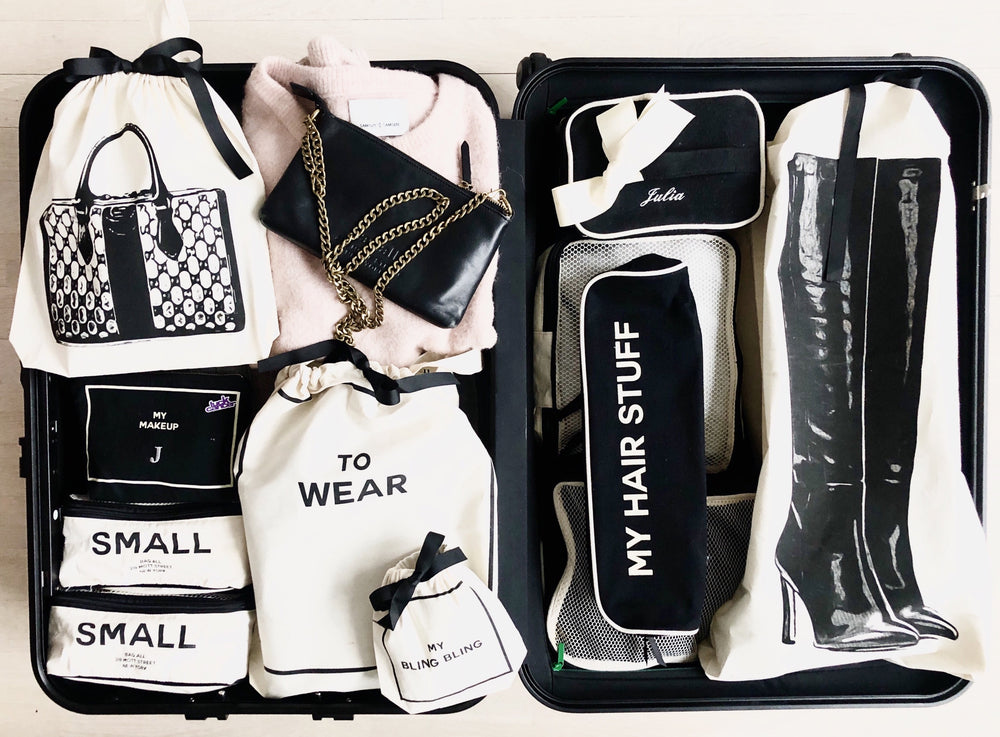 
                                      
                                        Valise emballée avec un mini sac en cuir, un grand sac à chaussures classique, un étui à cheveux, trois cubes d'emballage pour voyager et plus encore.
                                      
                                    