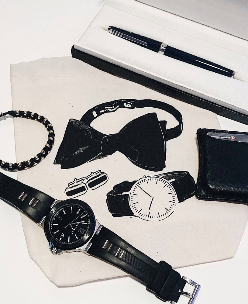 
                                      
                                        Sac d'accessoires pour homme avec une montre noire à l'intérieur du sac.
                                      
                                    