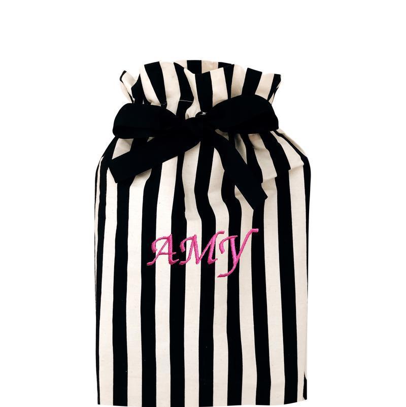 
                                      
                                        Un sac cadeau réutilisable rayé de taille moyenne avec "amy" monogrammé sur le devant.
                                      
                                    